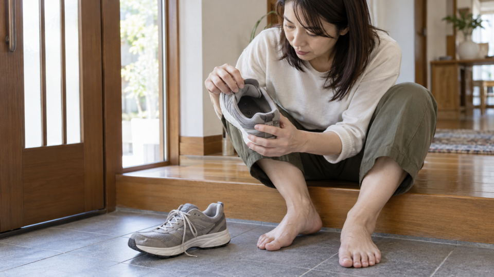靴を脱いで足元と靴の内側を確かめる様子