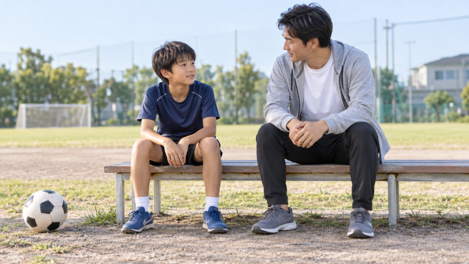運動後のベンチで保護者と話す子どもの説明用AI生成画像