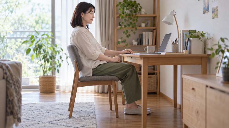 自宅の机で椅子に座る女性の説明用イメージ