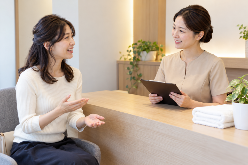 頭部のケア内容について受付で質問する女性